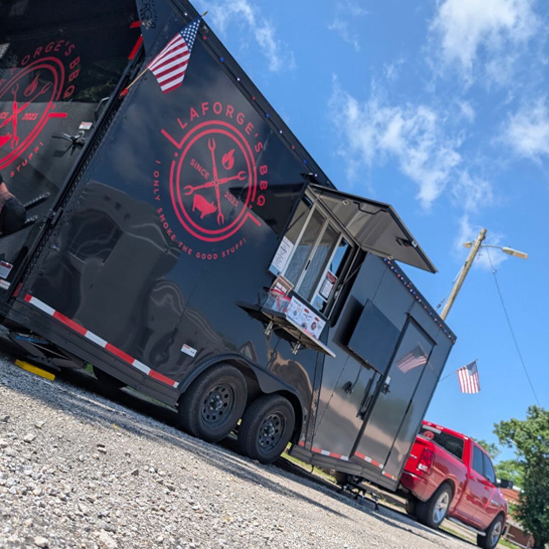 Low Angle Black Colored BBQ Food Truck with Red Ford Towing It